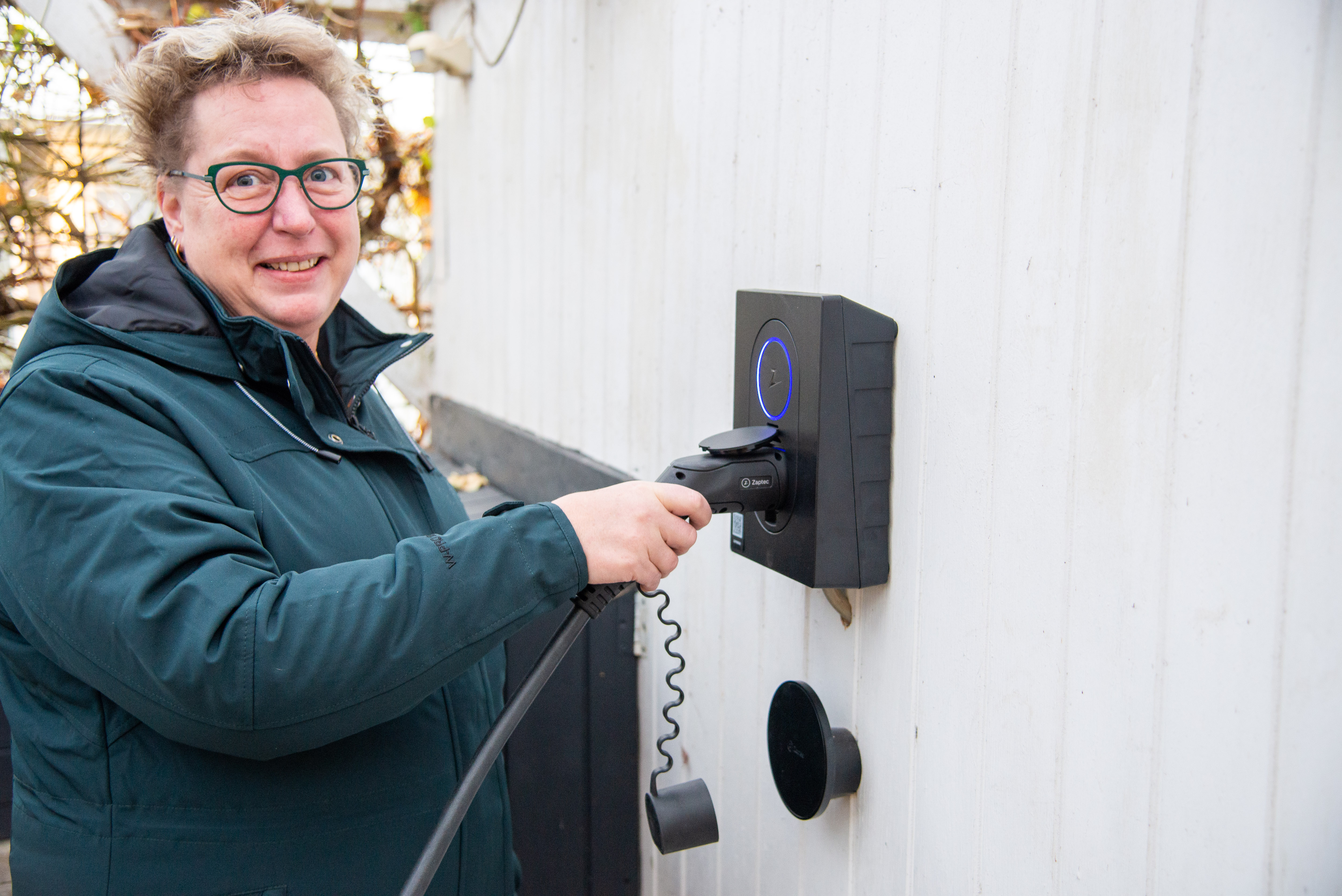 Kunde, der sætter ladekabel i sin nye ladeboks til elbilen - Installation af ladeboks på Kristiansgade, Ikast